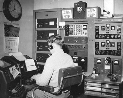 Aviation radio operator Andy Bennie in the tower at Musick Point, c1959