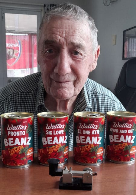 Bob ZL1AYN with 4 tins of baked beans bearing customised labels referring to him