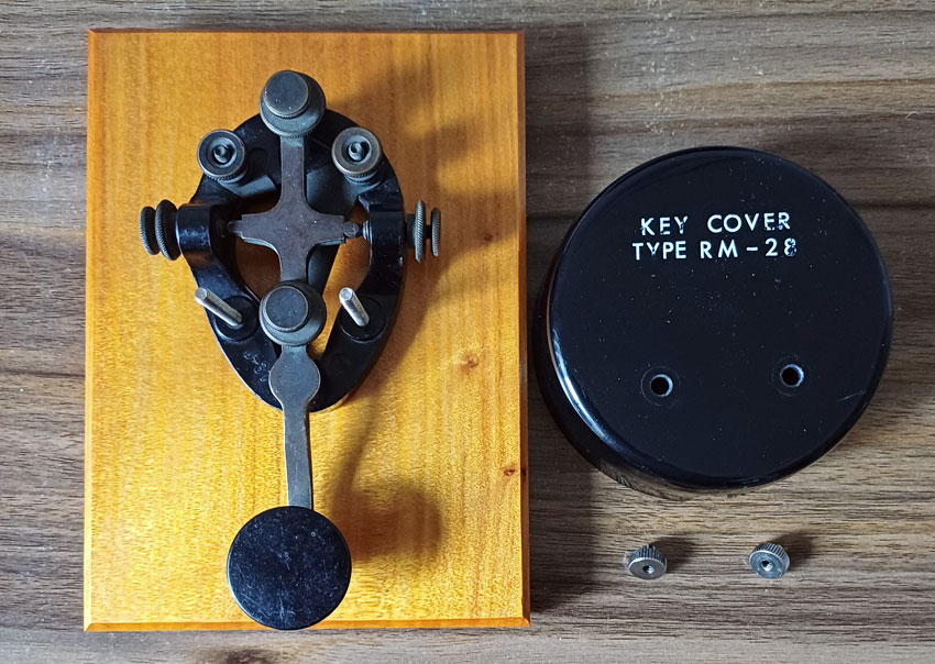 J-37 key mounted on timber, with its RM-28 cover beside it
