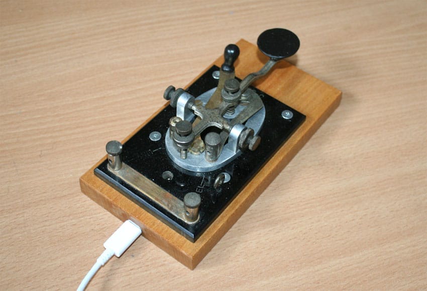 J-38 key on wood base with USB cable plugged in