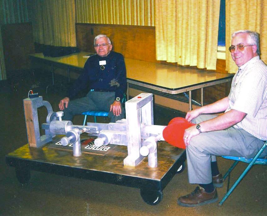 2 men seated with a huge Vibroplex bug built by one of them