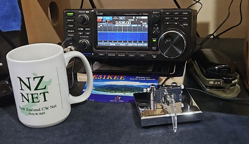 NZ Net coffee mug with keys and IC7300 in shack of ZL2KE