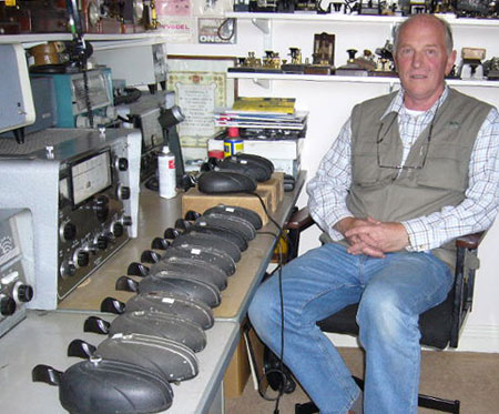 Richard Hall GM0OGN in his shack with about a dozen Eddystone bugs lined up on the desk