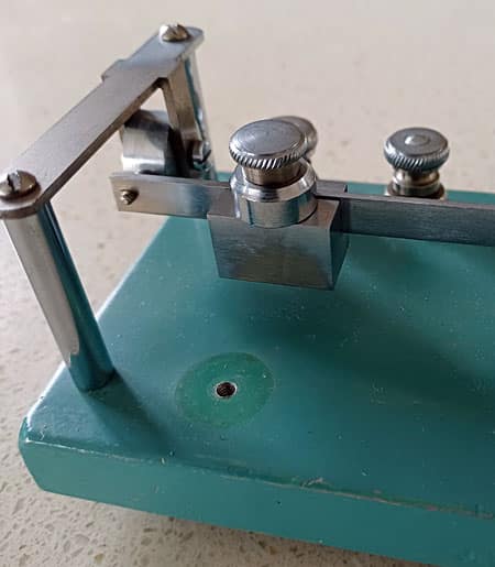 Photo shows the extra weight moved from its storage position on the base onto the top of the standard weight on the key's pendulum