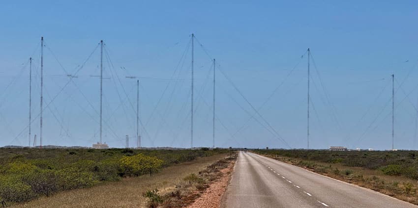 8 tall radio towers with a desert highway passing between them