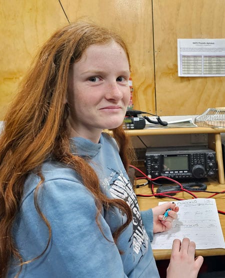 A girl writes out a radiogram message to be sent from the JOTA station