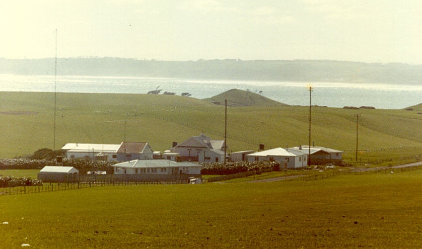 Low buildings with radio masts, sea in background