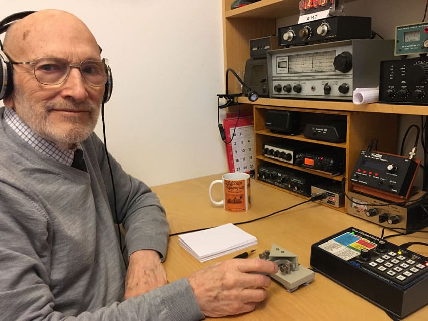 Radio amateur Tony Smith G4FAI using paddle at his home station, including a small Yaseu transceiver