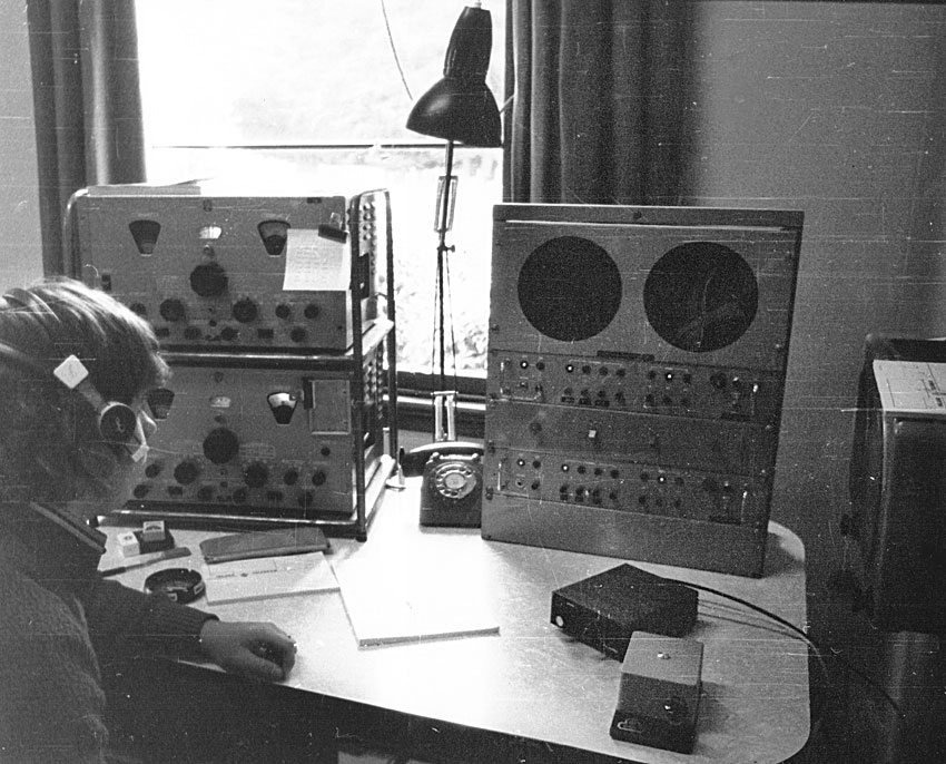 radio operator wearing headphones, with Philips receiver, Marconi morse key and other equipment