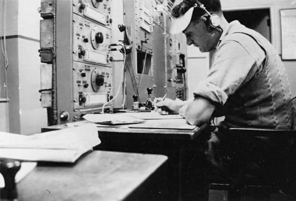 Nobby Clark at Auckland Radio ZLD in 1946 with three Collier and Beale HRO-type receivers
