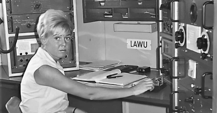 Radio operator using Morse key in ship radio room