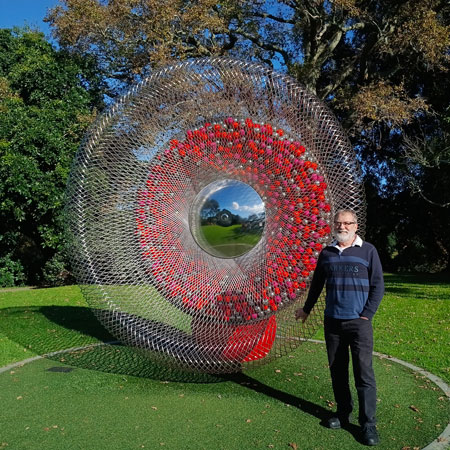 large disc shaped sculpture, looks a bit like a loudspeaker but made of stainless steel rods