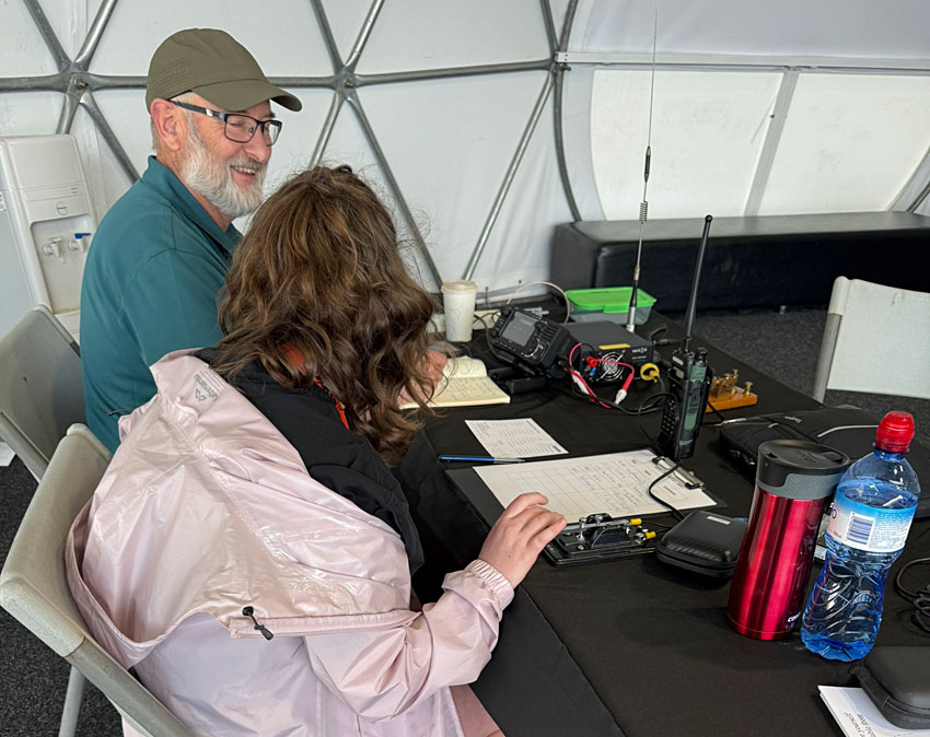 Man and girl seated at amateur radio equipment